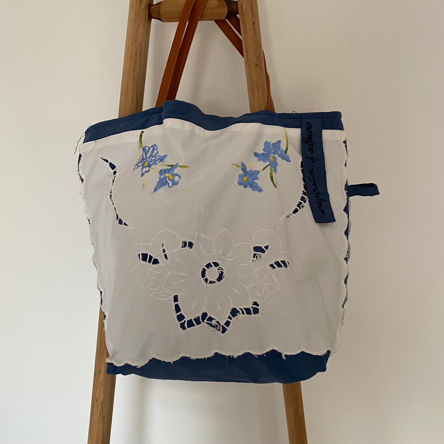 Cabas Gloria artisanal en drap ancien bleu avec napperon brodé fleur blanc et anses cuir camel